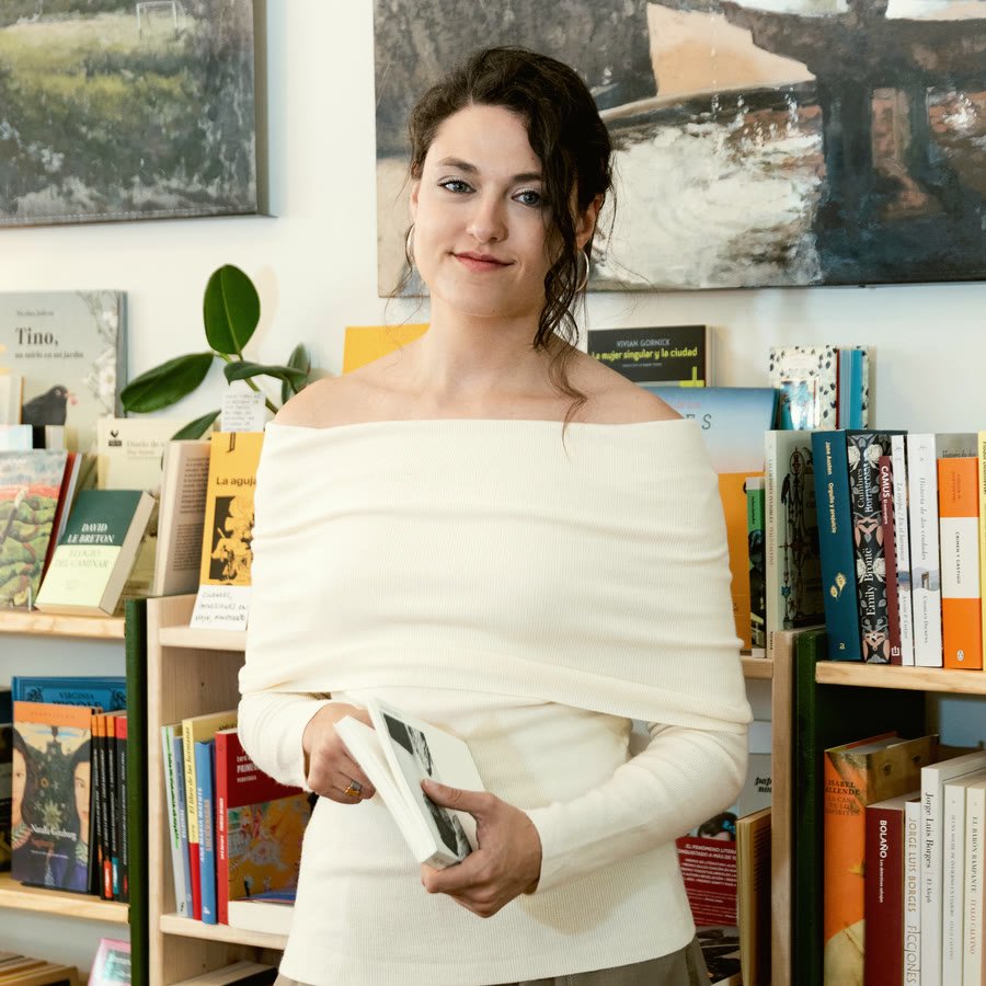 Antònia Busquets de pie, con un libro en las manos, en un espacio luminoso